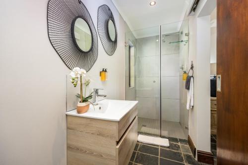 a bathroom with a sink and a mirror at Avemore Time Out - full power back up in Stellenbosch