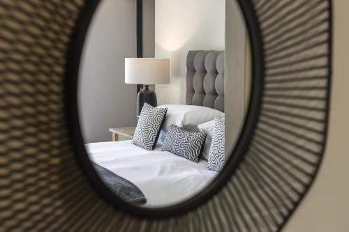 a mirror reflecting a bed with pillows on it at Avemore Time Out - full power back up in Stellenbosch