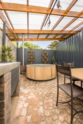 a patio with a table and chairs under a pergola at Avemore Time Out Le Verger in Stellenbosch