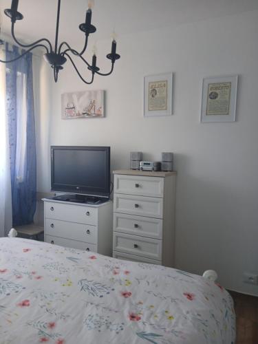 a bedroom with a bed and a television on a dresser at Casa Aurora Nicole in Pergine Valsugana