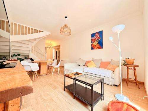 a living room with a white couch and a table at Vue rivière imprenable, 2 chambres, centre-ville in Besançon