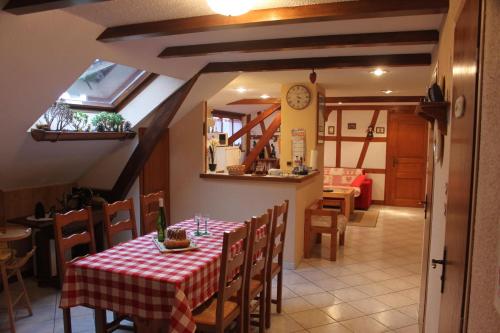 a dining room with a table with a red and white table cloth at Maison Alsacienne in Nothalten
