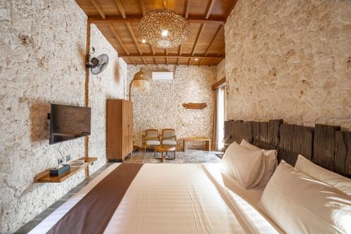 a bedroom with a bed in a stone wall at Imalee - Cottage in Yogyakarta