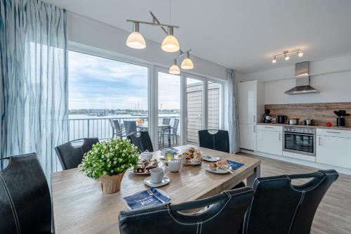 a kitchen and dining room with a table and chairs at Maisonette Fewo Kapteins Lounge by Seeblick Ferien ORO, Rundum Wasser, 6Pers, Sauna, Kamin in Olpenitz