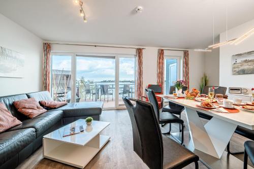 a living room with a couch and a table at Schleivilla Lootsen Hus by Seeblick Ferien ORO, 3Etagen,8Pers,Sauna,Kamin in Olpenitz