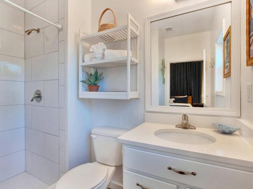 a bathroom with a toilet and a sink and a mirror at Lime Time in Tybee Island