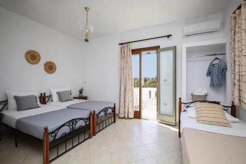 a bedroom with two beds and a balcony at Eleonas 2 in Maragkas