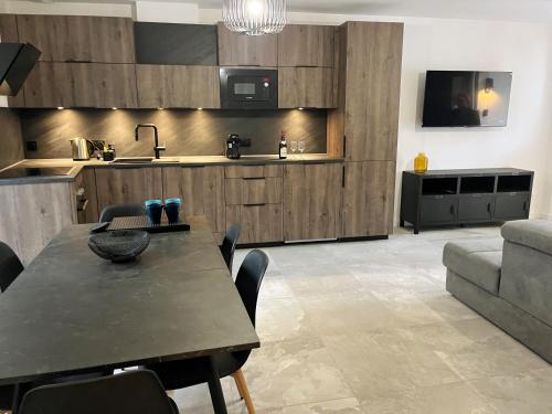 een woonkamer met een tafel en een keuken bij Le Vieux Bourg Apartment 2 in Le Bourg-dʼOisans