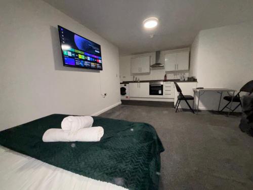 een slaapkamer met een bed met twee handdoeken erop bij Cosy Modern Studio Apartement in Ilkeston