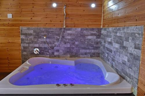 a large blue tub in a room with a shower at אחוזת אודליה במושב דלתון in Shahar