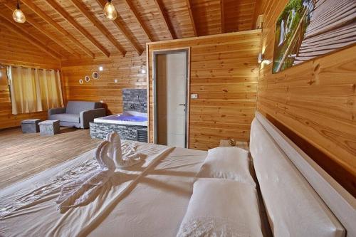 a bedroom with a large bed in a wooden room at אחוזת אודליה במושב דלתון in Shahar