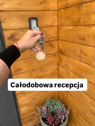a person is holding a key to a door at Dream Catcher House - dom do wynajęcia w górach in Limanowa