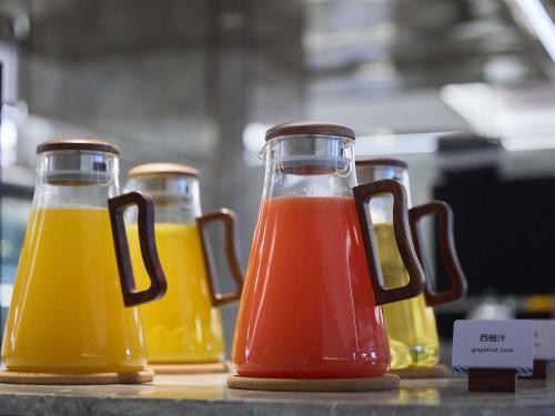 Cuatro botellas de jugo sobre una mesa en Mercure Yiwu International Trade City, en Yiwu