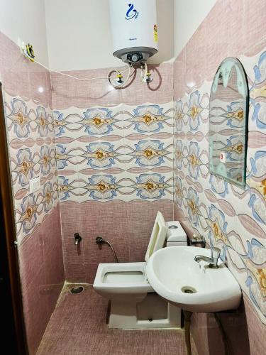 a bathroom with a sink and a toilet and a mirror at Hotel Krishna Gorakhpur in Gorakhpur