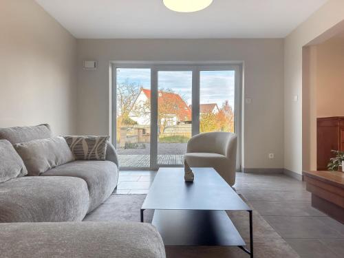 ein Wohnzimmer mit Sofa und Tisch in der Unterkunft Maison contemporaine de 150 m2 avec garage privé et terrasse ensoleillée in Monswiller