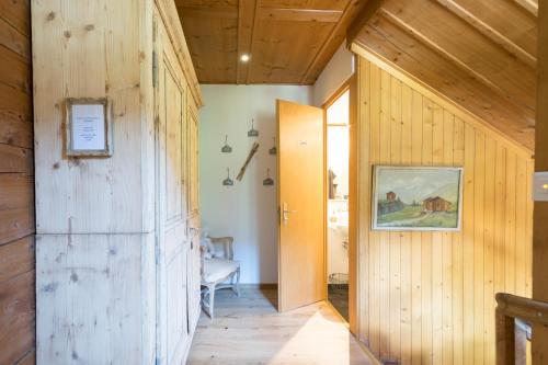 een hal van een huis met houten wanden en een deur bij La Providence in Morgins