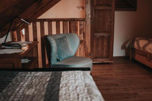 a chair in a room with a desk and a bed at Chalupa na Horce in Blata