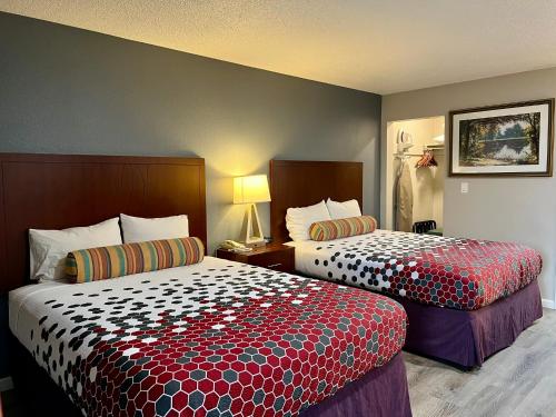 a hotel room with two beds in a room at Travelers Inn Eugene University in Eugene