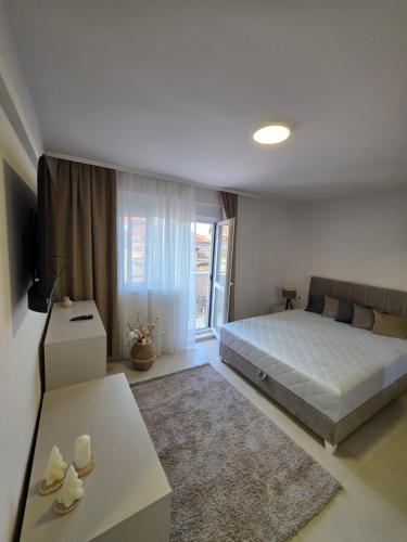 Un dormitorio con una cama, una mesa y un sofá. en Apartman Bibi centar, en Niš