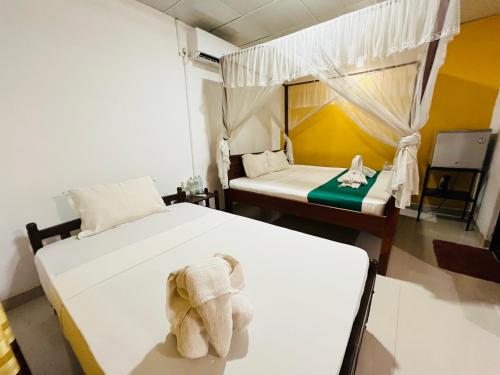 a room with two beds with a stuffed elephant on it at Palitha Homestay in Sigiriya