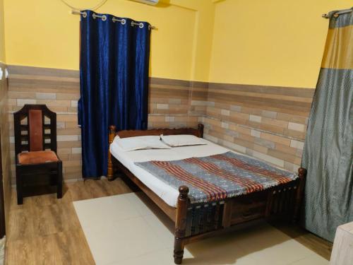 Un dormitorio con una cama y una cortina azul. en Moonstar guesthouse, en Māvalli