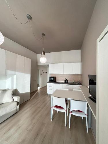 a kitchen and living room with a table and chairs at Rucola Home in Castione della Presolana