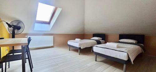 a room with two beds and a desk and a window at Redwood Hostel by EASY RENT Apartments in Lublin