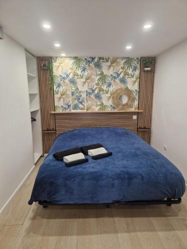 a bedroom with a blue bed with two towels on it at Le petit céretant in Céret