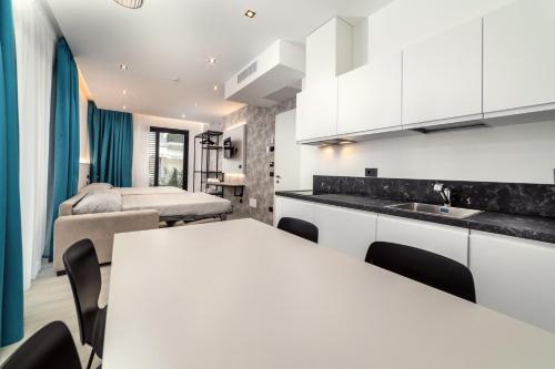 a kitchen and living room with a white table and chairs at Residence Cala Vela Tower in Riccione