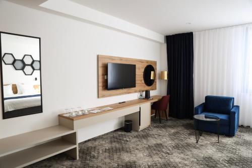 a hotel room with a desk and a tv and a chair at Hotel Karting in Mostar