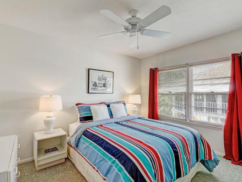 a bedroom with a bed and a ceiling fan at Coops Retreat in Tybee Island