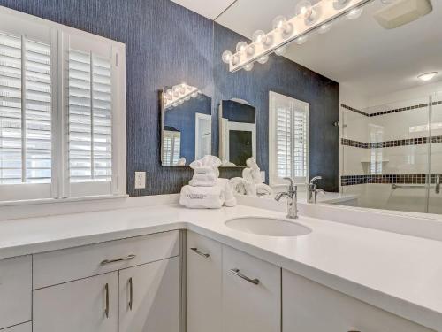 a white bathroom with a sink and a mirror at Coops Retreat in Tybee Island