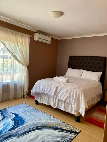 a bedroom with a bed and a window and a rug at Ubuntu Guest House in Cape Town