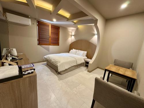 a bedroom with a bed and a desk in a room at 계룡 호텔 스테이318 in Gyeryong