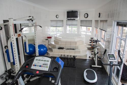 a room with a gym with a machine and equipment at Ekupholeni Garden Villas in Manzini