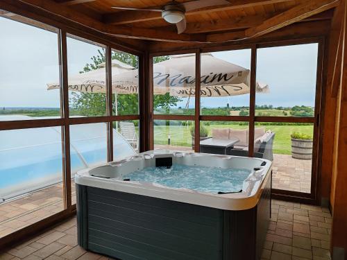 une baignoire jacuzzi dans une chambre avec patio dans l'établissement Kuća za odmor Krolo - Blackberry Hill, à Kupinovac