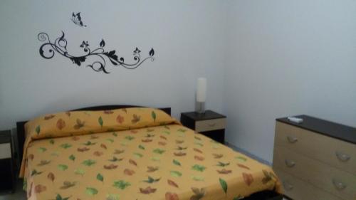 Casa Trinacria في مستربيانكو: غرفة نوم مع سرير مع اوراق الشجر والفراشات على الحائط