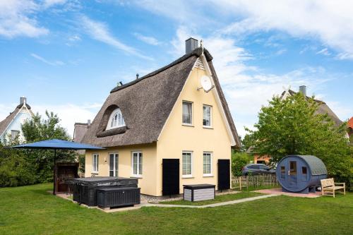 a house with a gambrel roof with a grill at Reethaus Elster Mit Whirlpool Und Sauna in Gramkow