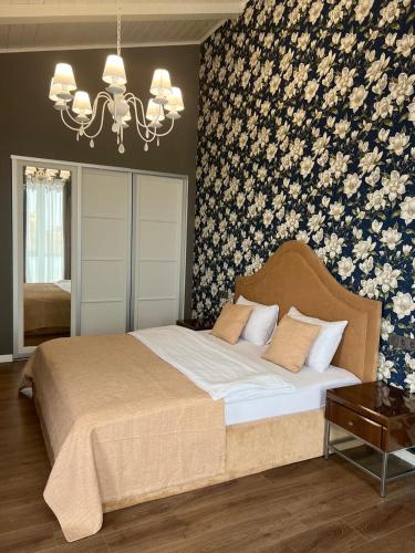 a bedroom with a large bed with a floral wallpaper at Prestige Apartment in Mykolaiv