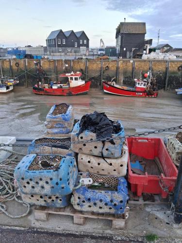 Ein Stapel Container steht mit Booten in einem Hafen. in der Unterkunft The Slopes in Whitstable