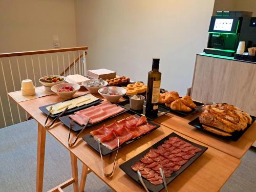 une table avec un tas de nourriture et une bouteille de vin dans l'établissement Líbere Barcelona Sant Antoni, à Barcelone