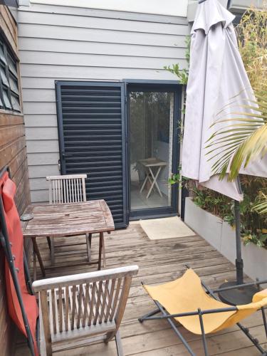 a patio with a table and chairs and an umbrella at Chambre avec salle de bain, WC et terrasse in Étang-Salé