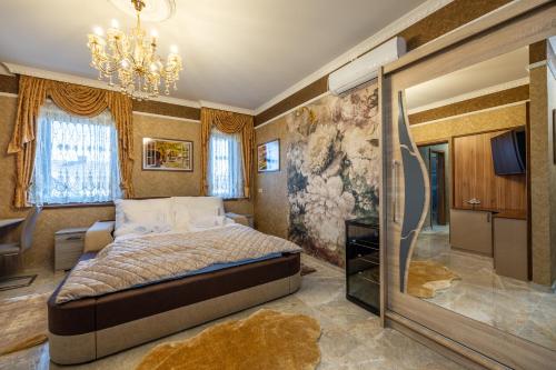 Un dormitorio con una cama y una lámpara de araña en Vörös Álom Apartman Panzió, en Tiszakécske