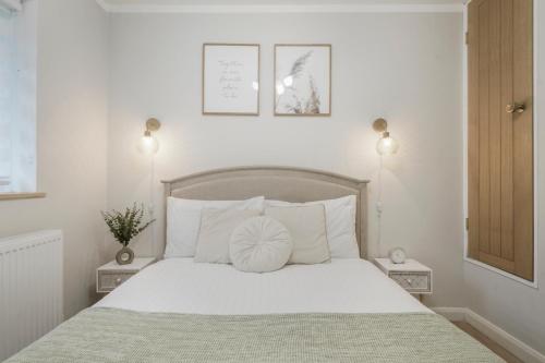 a bedroom with a white bed with a white pillow on it at Milton Keynes 3BR,Spacious Home, Sleeps 5, Families Stays, Free Parking in Milton Keynes