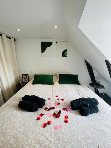a bed with red rose petals on it at Bulle de douceur en hypercentre in Quimper