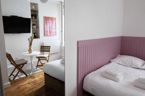 een slaapkamer met een bed met een roze hoofdeinde bij DA-3-TURENNE-BM near Place des Vosges in Parijs