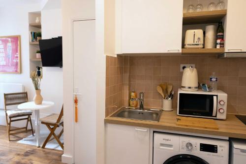 een keuken met een spoelbak en een magnetron bij DA-3-TURENNE-BM near Place des Vosges in Parijs
