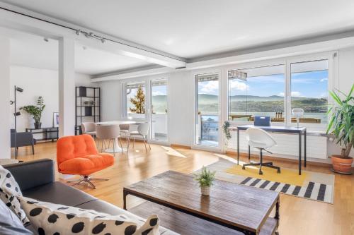 an open living room with a table and chairs at EXQUIS Design 3-Room Apartment KNOLL I Zurich Lake View I Balcony I Family-Friendly in Männedorf