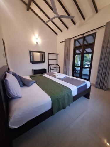 a bedroom with a large bed and a window at BIVORA Villa in Negombo