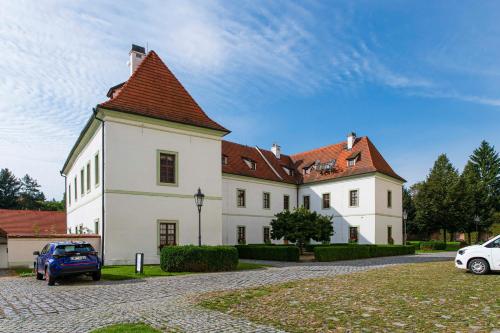a large white building with a red roof at Adalbert Ecohotel in Prague